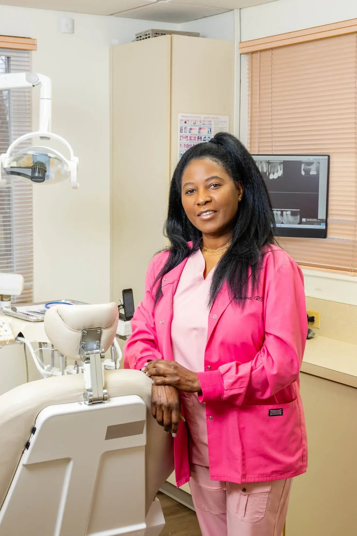 Dentist in pink scrubs at clinic.