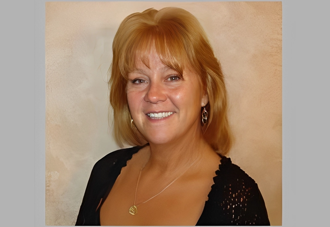 Smiling woman with short blonde hair.