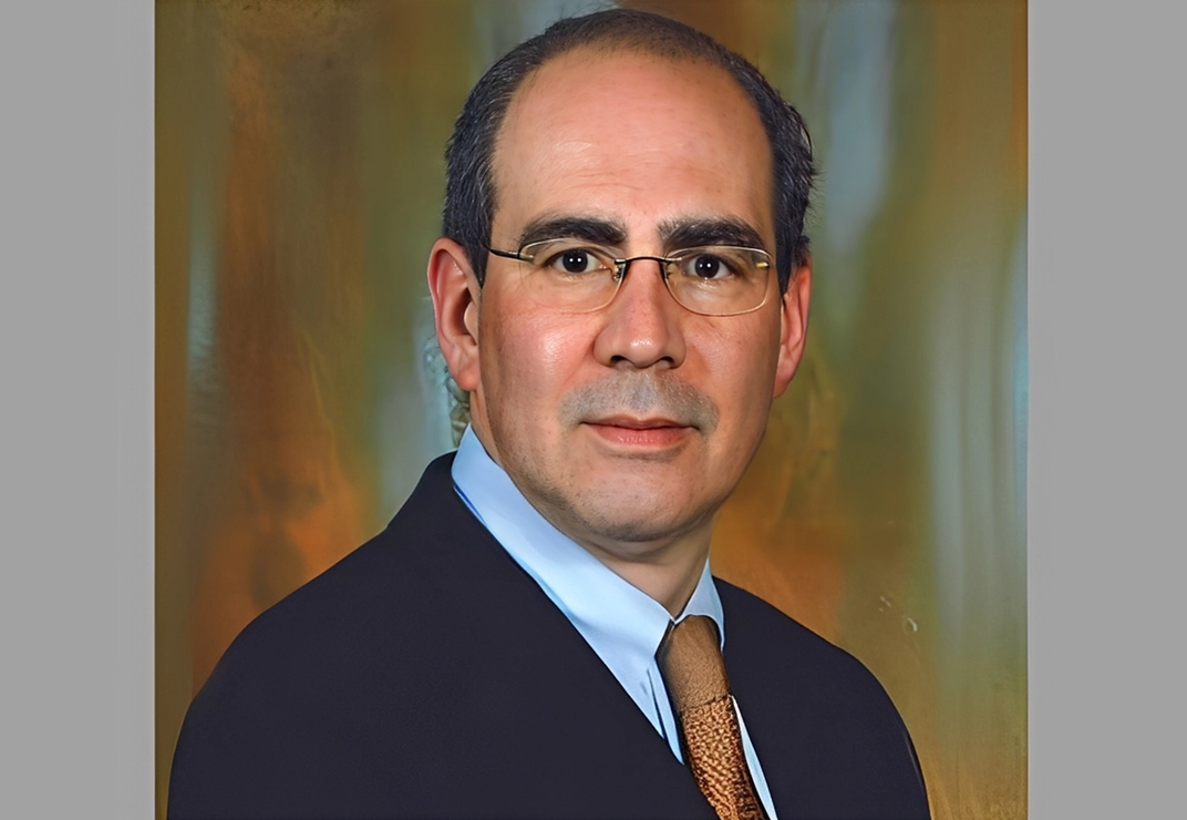 Man in suit with glasses and tie.