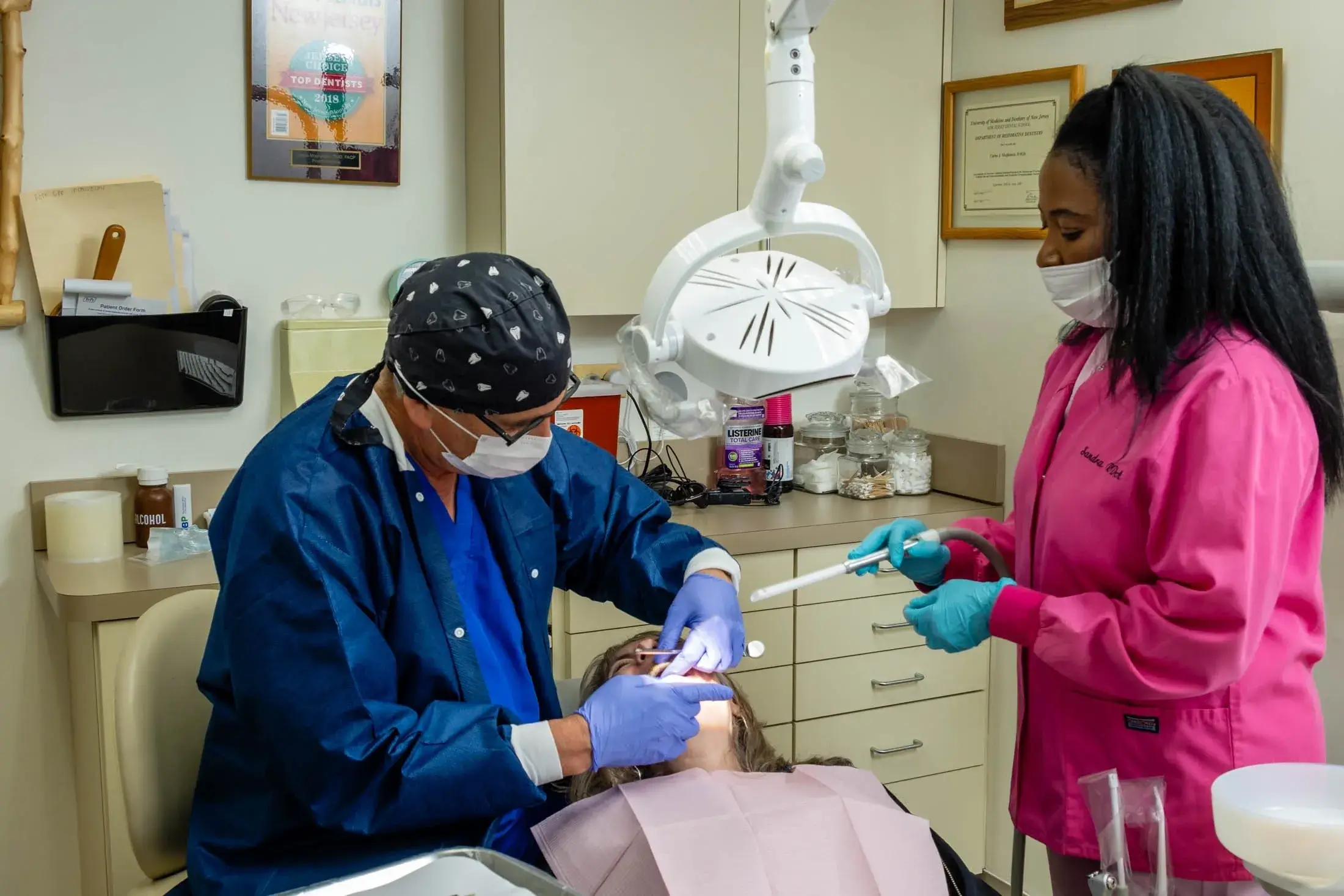 Dentist and assistant performing dental procedure.