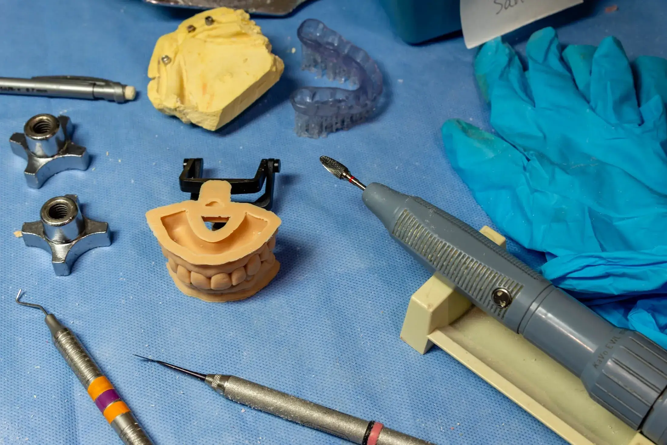 Dental tools and models on blue cloth.